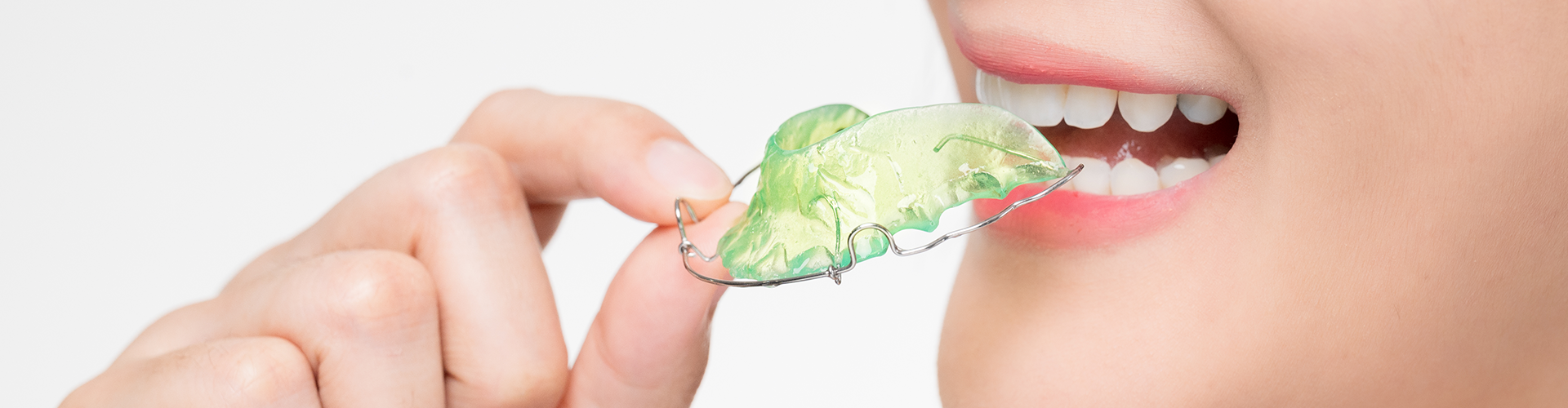 woman placing retainer in mouth